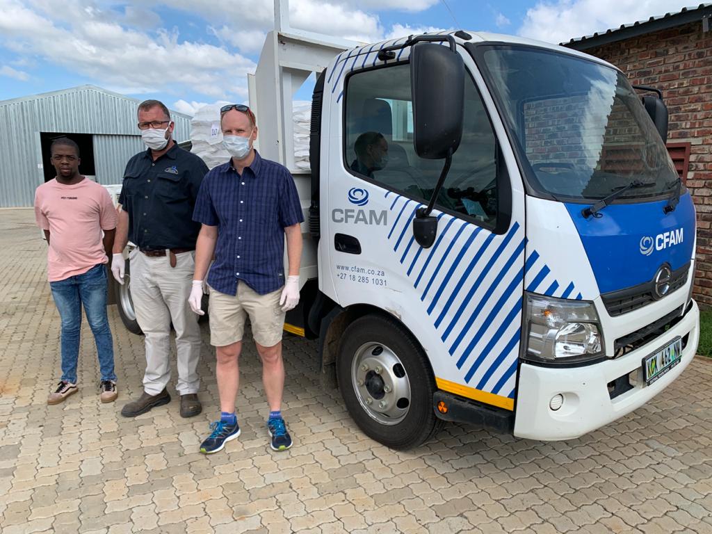 Mr. Itumeleng Matlhabe (Bana ba Kae representative), Mr. Danie Vorster (CFAM), Mr. Jonathan Baron (Chairman of the Potchefstroom Chamber of Commerce). The truck here is loaded with 15 000 meals, ready to be distributed to people in need.